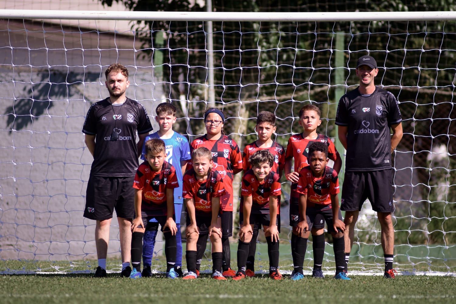 Equipe do Trieste e professores em frente ao gol